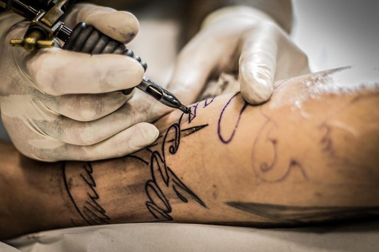 Ons Team Verse tattoo met scherpe kleuren die oververzorging kan verpesten door uitdroging en zonlicht